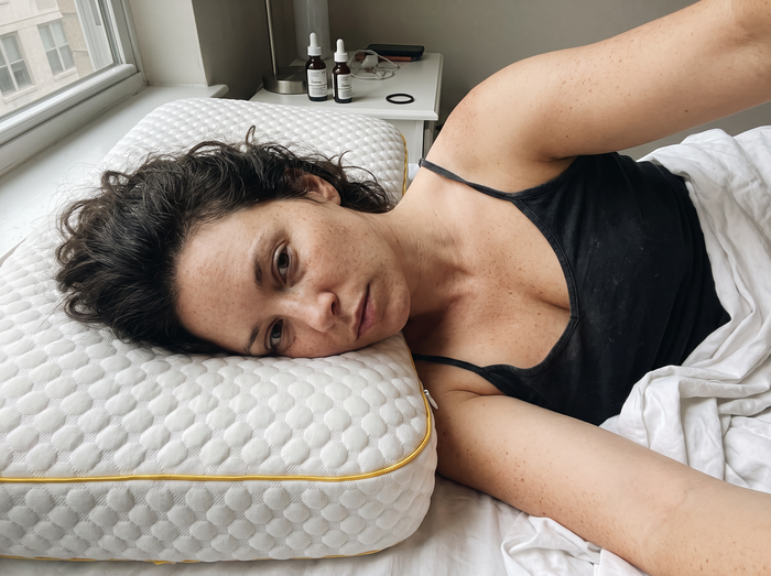 Close-up of a woman lying with her cheek on a clean Pillowash washable pillow in morning window light