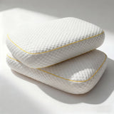 Two Pillowash Crisp pillows stacked on a white studio surface, yellow piping tracing the edge of each cover